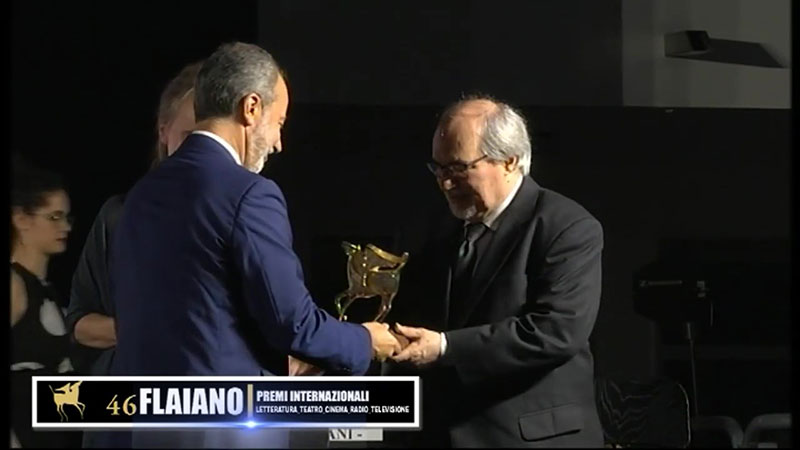 Alessandro Carrera on stage receiving award statue