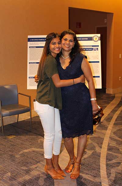 A mother and daughter hug eachother.