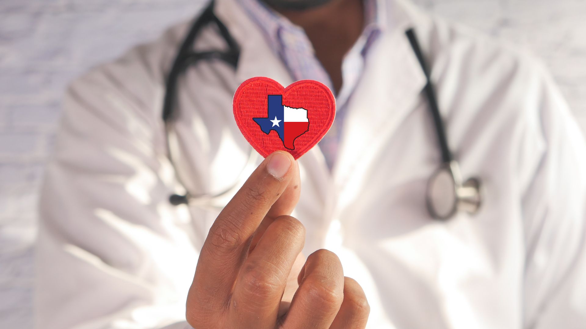 Docter holding heart with Texas icon contained within