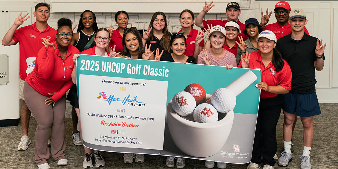 students holding golf sponsor banner